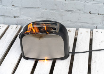 Brennender Toaster auf einem Gartentisch; Copyright Panthermedia
